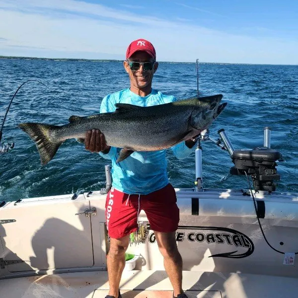 Angler with a king salmon on a calm blue day