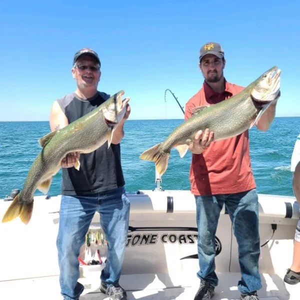 Two anglers each holding a trout